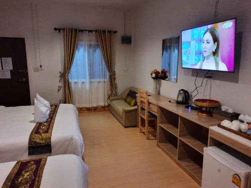 a hotel room with two beds and a flat screen tv at Hotel Pailifornia in Pai