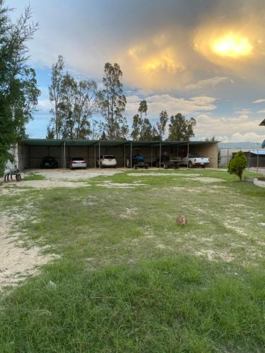 a building with two cars parked in a yard at Farm Lodge La Cabaña 