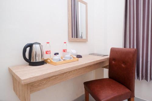 een kamer met een aanrecht met een stoel en een spiegel bij Urbanview Hotel DJ Inn Tegal in Tegal