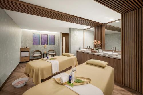 a spa room with three beds and a sink at DoubleTree by Hilton Damai Laut in Lumut