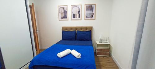 een slaapkamer met een blauw bed met 2 handdoeken erop bij Sobrado com 3 Suítes, Piscina, Sala de Jogos, Playground, Garagem para 4 Carros in Florianópolis