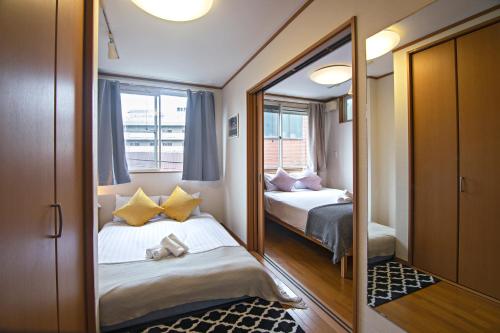 Habitación pequeña con 2 camas y espejo. en 五卧室别墅 毗邻大阪城公园 en Osaka