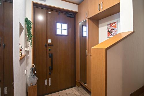 un pasillo con una puerta de madera en una casa en 五卧室别墅 毗邻大阪城公园 en Osaka