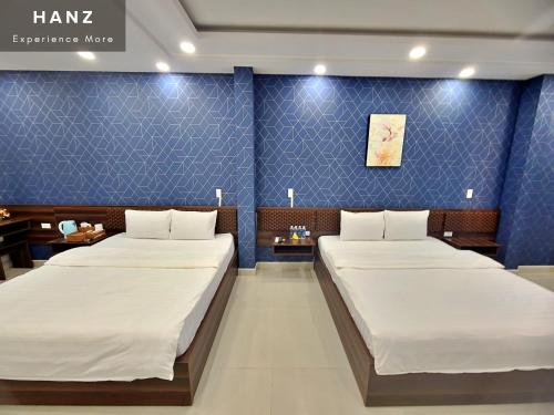- 2 lits dans une chambre aux murs bleus dans l'établissement HANZ Hung Phu Hotel, à Hô-Chi-Minh-Ville