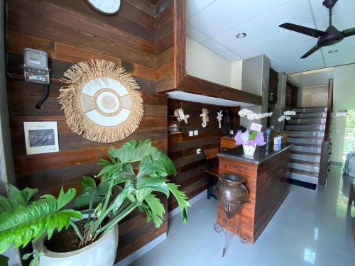 a lobby with wooden walls and plants and a clock at Alu Lofts in Seminyak