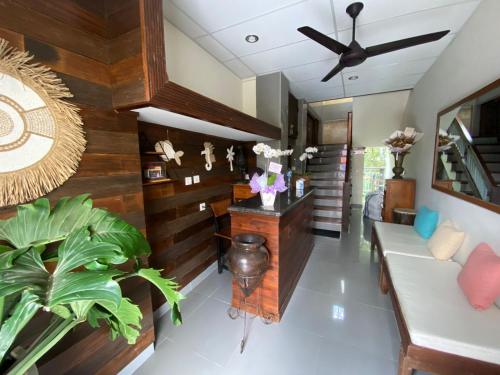 a living room with wooden walls and a ceiling fan at Alu Lofts in Seminyak
