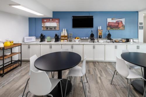 a dining room with two tables and a tv at Super 8 by Wyndham Laredo in Laredo