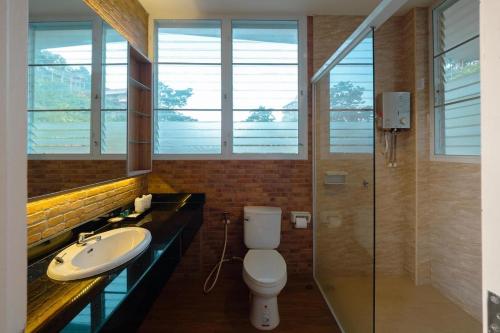 a bathroom with a toilet and a sink and windows at The private 2 @ khao kho in Khao Kho