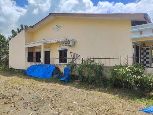 dom z niebieską plandeką przed nim w obiekcie Pematang Siantar Vacation House w mieście Pematangsiantar