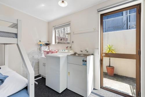 a small bathroom with a sink and a bunk bed at Pilot Bay Pad - Mount Maunganui Holiday Home in Mount Maunganui