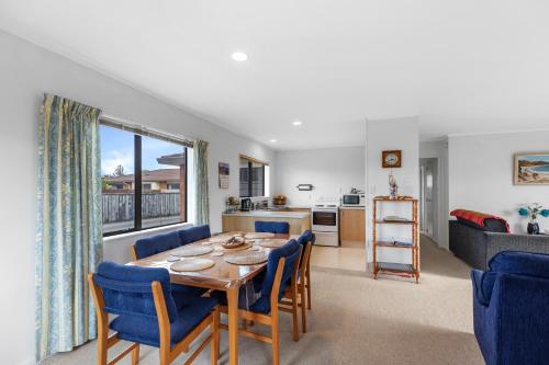 a dining room with a table and chairs and a kitchen at Riviera Casa - Mount Maunganui Holiday Home in Mount Maunganui