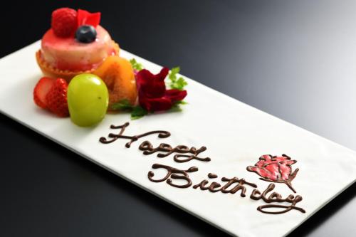 a cake with fruit on a plate with the words happy birthday at Kami no yama Azumaya in Kaminoyama
