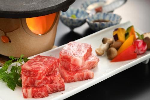 a plate of meat and vegetables on a table at Kami no yama Azumaya in Kaminoyama
