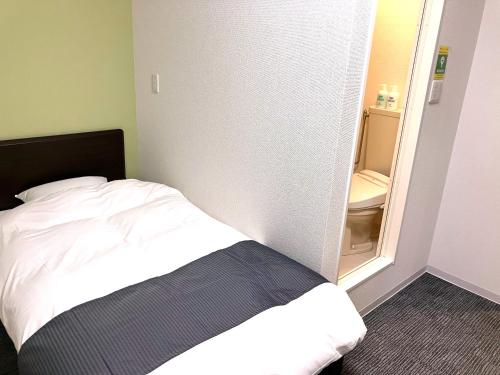 Dormitorio pequeño con cama y espejo en IMAS Village Court Rokkokuodaka, en Minamisouma