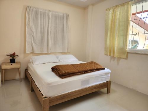 a bed sitting in a room with a window at HOMEis Villa Sattahip in Ban Tao Than