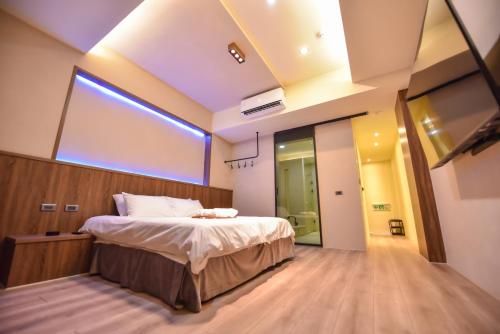 a bedroom with a bed and a large window at Two Couples Leisure Art Motel in Tainan