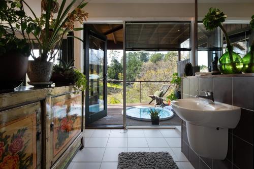 baño con lavabo y vistas a un patio en Treehouse Spa Villa Daylesford, en Daylesford