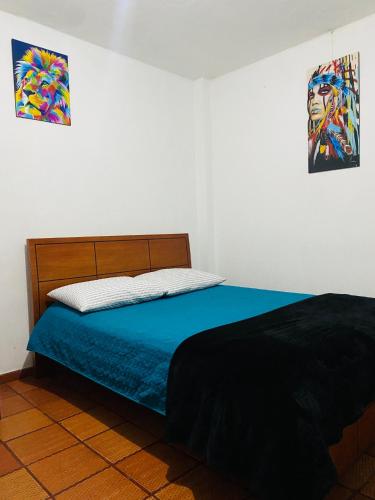 una camera da letto con un letto con lenzuola blu e un dipinto di Bogotá Kings 101 a Bogotá