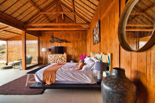 a bedroom with a bed in a room with wooden walls at Lobster Bay Lombok in Awang