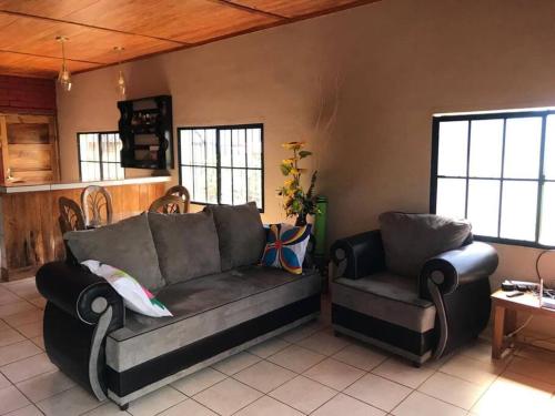 een woonkamer met een bank en een stoel bij Los Cipreses-10persons-Deep connection with nature 