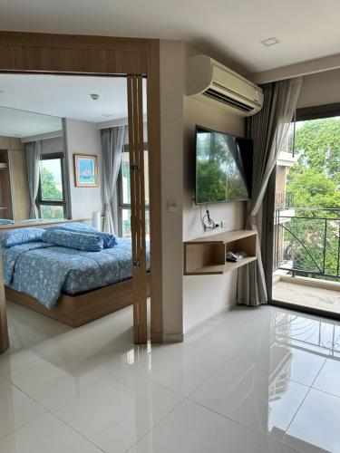 a bedroom with a bed and a flat screen tv at City Garden Tropicana Condo Naklua in Pattaya North