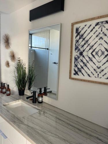 a bathroom with a sink and a mirror at Luxury Penthouse w Glass Wall, Roof Deck, Firepit in DT Austin in Austin