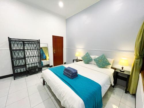 a bedroom with a bed with blue and white sheets at Birdcage Boutique in Phnom Penh