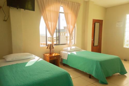 a bedroom with two beds and a window at Casa de Nelly in Puerto Baquerizo Moreno