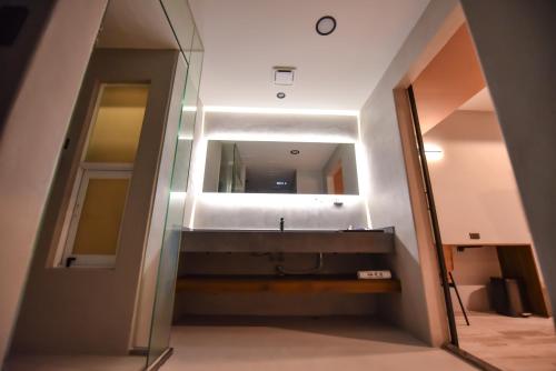 a bathroom with a sink and a mirror at Two Couples Leisure Art Motel in Tainan
