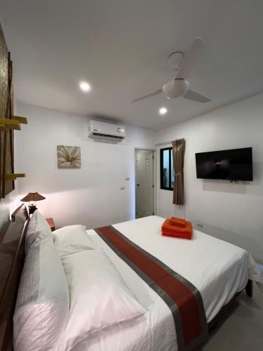 una camera con un grande letto e una TV a schermo piatto di Super Som Rawai a Rawai Beach
