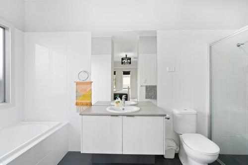 een witte badkamer met een wastafel en een toilet bij 94 Blanche Parade, Hindmarsh Island in Hindmarsh Island
