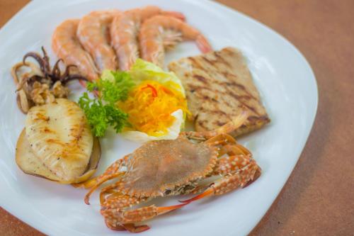 a white plate of food with lobster and other foods at Mithi Resort & Spa in Panglao