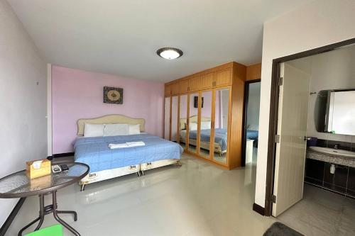 合艾的住宿－星別墅度假旅館，一间卧室配有一张床、一张桌子和一台电视。