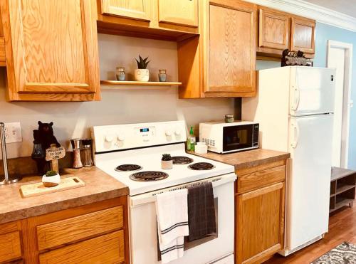 W kuchni znajduje się biała kuchenka i kuchenka mikrofalowa. w obiekcie The Bear’s Den w mieście Charleston