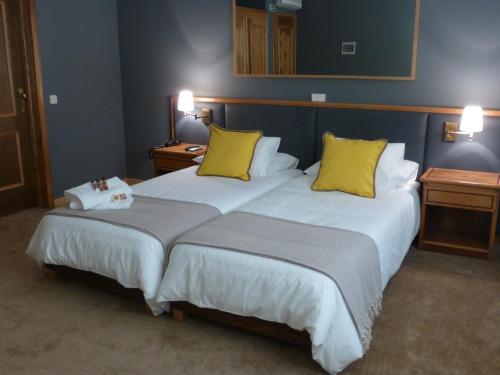 a hotel room with two beds with yellow pillows at Cosy Sintra in Sintra