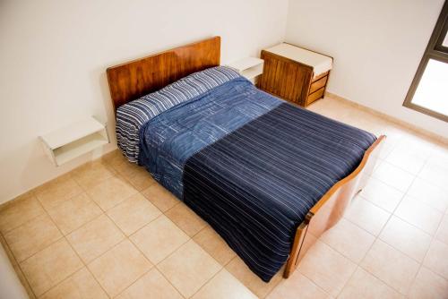 ESTE SUEÑO في سان مارتين: سرير كبير مع لحاف أزرق في غرفة النوم
