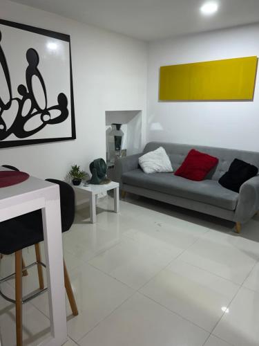 een woonkamer met een bank en een tafel bij Apartaestudio Barranquilla Recreo, primer piso in Barranquilla