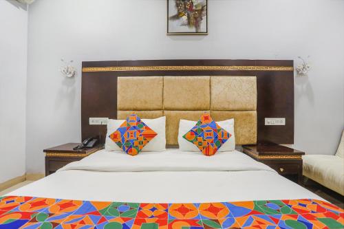 a bedroom with a large bed with colorful pillows at FabHotel Star Residency in Nagpur