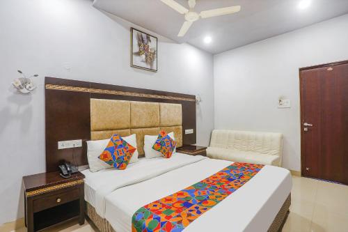 a bedroom with a large bed and a chair at FabHotel Star Residency in Nagpur