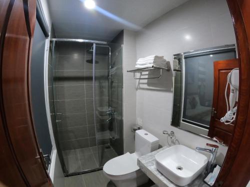a bathroom with a shower and a toilet and a sink at Huong Duong Sunflower in Ha Long
