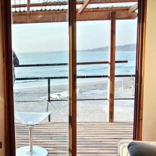 una puerta de cristal con vistas al océano en Casa playa ConCon, en Concón
