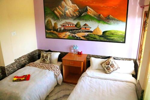 a room with two beds and a painting on the wall at Hotel National Park- A Peaceful Family Home in Sauraha in Chitwan