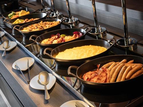a row of pans filled with food on a stove at Hotel Il Palazzo in Fukuoka
