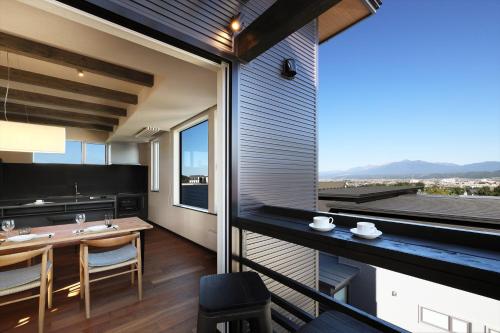 a room with a balcony with a table and chairs at Apres in Furano