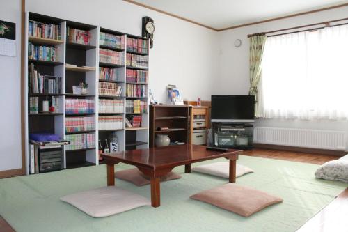 a living room with a coffee table and bookshelves at Bon's Home in Shari
