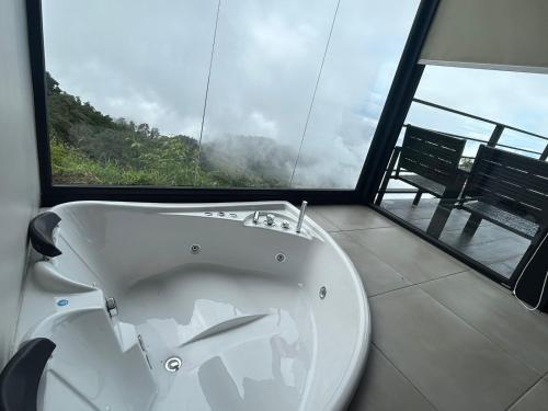 - białą wannę w pokoju z oknem w obiekcie Villas Páramo Cloud Forest Hotel w mieście División