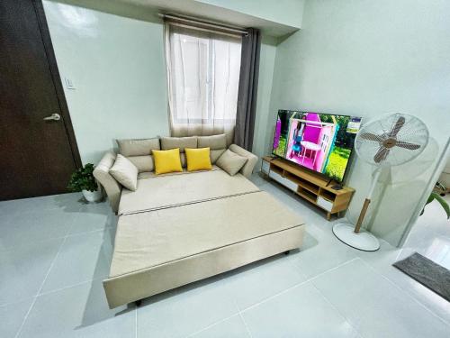 Il comprend un salon doté d'un canapé et d'une télévision à écran plat. dans l'établissement QFandZ Baguio Homestay at Brenthill Condominium, à Baguio
