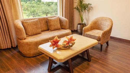 a living room with a couch and a table at Palasa Hotel in Muzaffarnagar