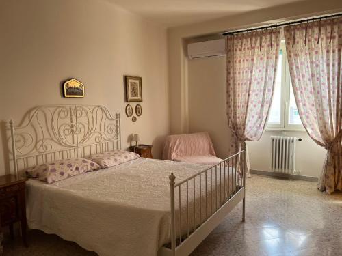 ein Schlafzimmer mit einem weißen Bett und einem Fenster in der Unterkunft Casa Gentile Carducci in Gioia del Colle