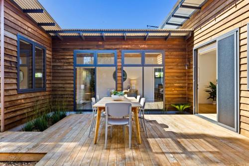 a wooden deck with a table and chairs on it at Naturally Shoreham in Shoreham